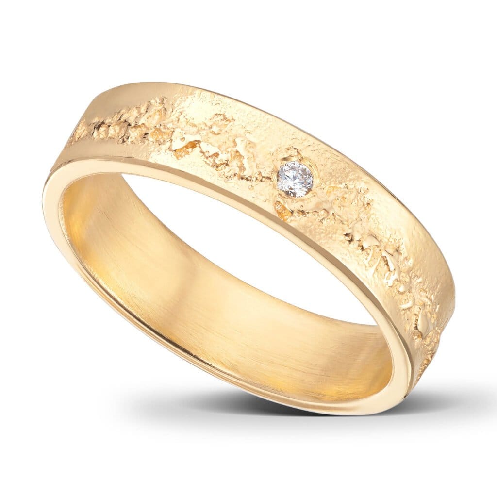 Ehering mit gealterter Oberfläche und geraden Kanten. 14 Karat Gelbgold. 1 Diamant.