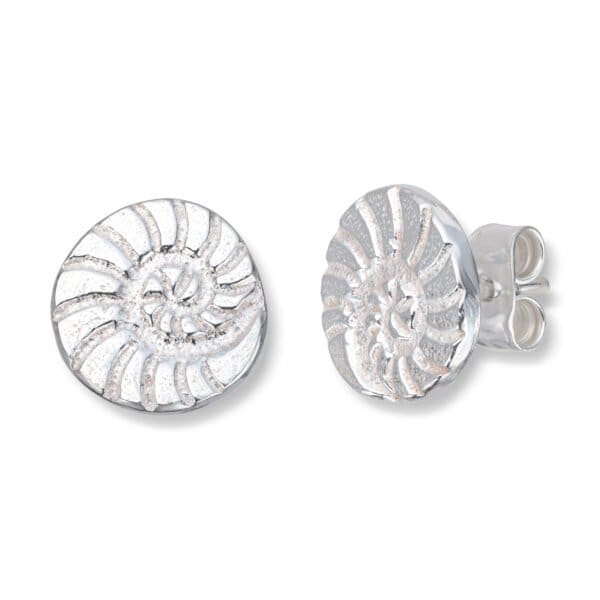 Et par små øredobber, ca 10 mm, rund form. 14 karat hvitt gull, formet som en konkylie. Et design-samarbeid med Tromsø musiker Aggie Frost