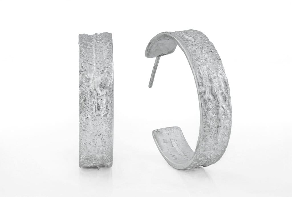 25 mm große Ohrringe in Silber, 8 mm breit. Zerklüftete Oberfläche. Gewicht ca. 7 Gramm pro Stück
