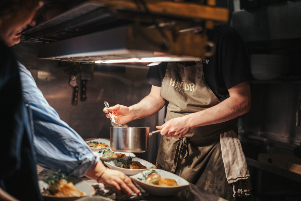 Kokk fra restaurant Hildr i Tromsø legger opp mat på kjøkkenet før servering til gjestene som deltar på Mingle Workshop og middag, et samarbeid mellom Gallery Wabi Sabi og Hildr.