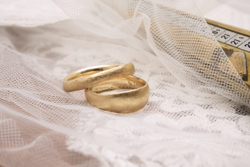 Wave and Swell wedding rings in 14 karat yellow gold with a wavy shape and rough surface